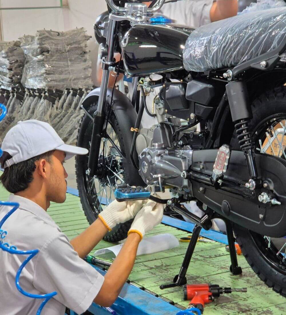 Person installing a part on a Calypso motorcycle on the assembly line