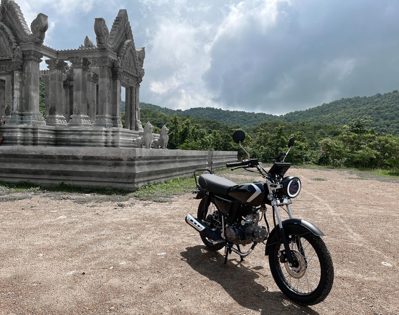 Calypso Ori motorcycle parked with an Asian historical site in the background